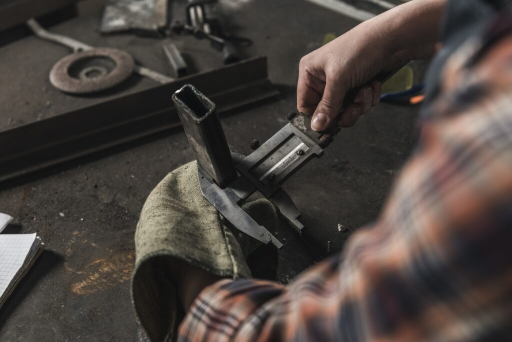 partial view of welder working on peace of metal in workshop